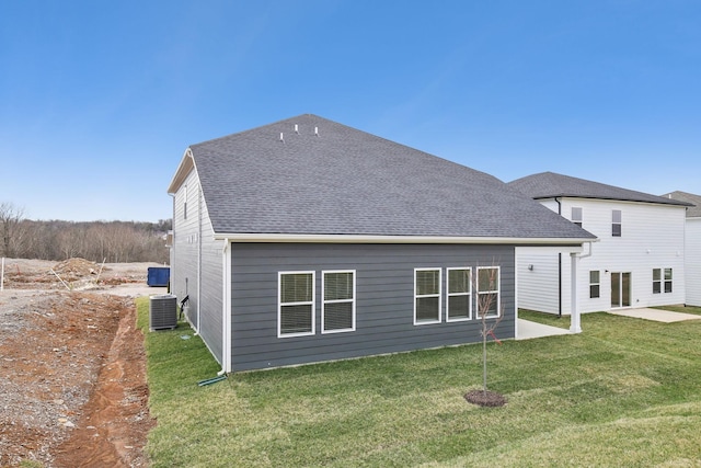 back of property featuring a patio area, roof with shingles, a yard, and central air condition unit