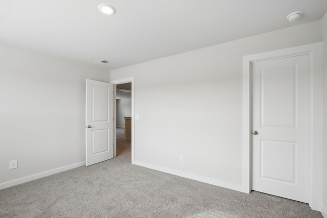 unfurnished bedroom with light carpet, visible vents, and baseboards