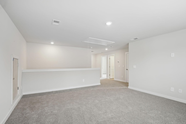 spare room with light carpet, attic access, visible vents, baseboards, and recessed lighting