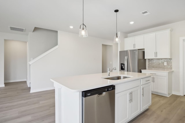 kitchen with stainless steel appliances, light countertops, and white cabinets