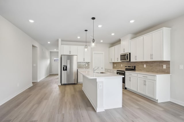 kitchen with stainless steel appliances, light countertops, and white cabinetry