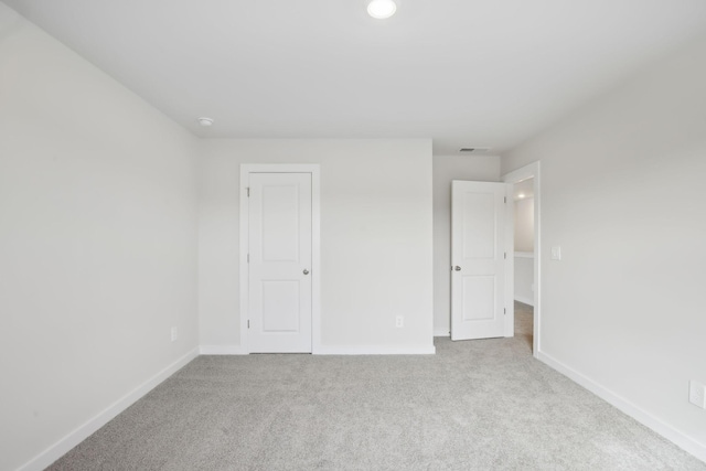 unfurnished bedroom with visible vents, baseboards, and light colored carpet