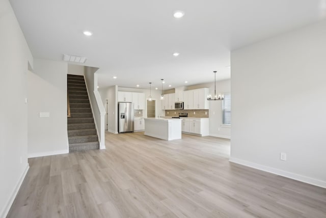 unfurnished living room with stairs, light wood-type flooring, visible vents, and recessed lighting