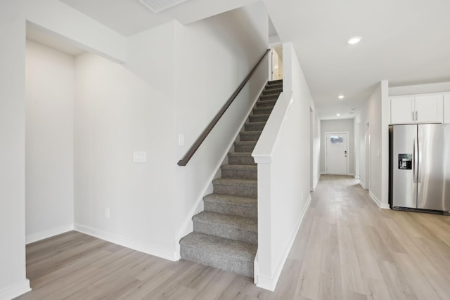 stairs with recessed lighting, baseboards, and wood finished floors