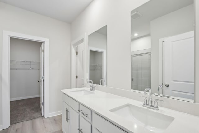 full bathroom featuring visible vents, a sink, baseboards, and double vanity