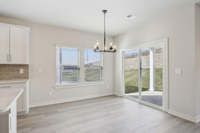 unfurnished dining area featuring light wood finished floors and plenty of natural light