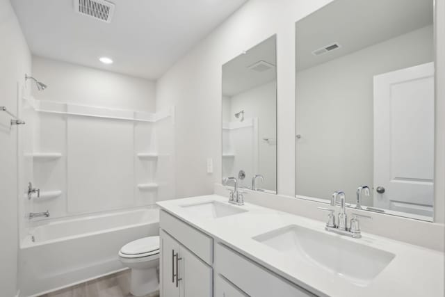 full bath featuring toilet, a sink, and visible vents