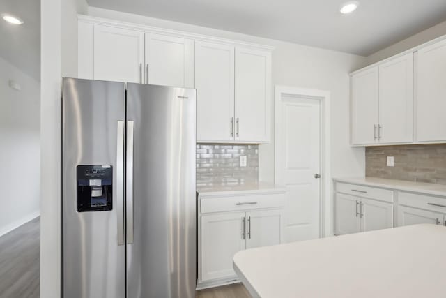 kitchen featuring decorative backsplash, white cabinets, light countertops, and stainless steel fridge with ice dispenser