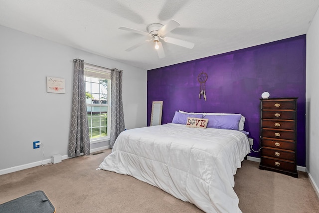 carpeted bedroom with a textured ceiling and ceiling fan