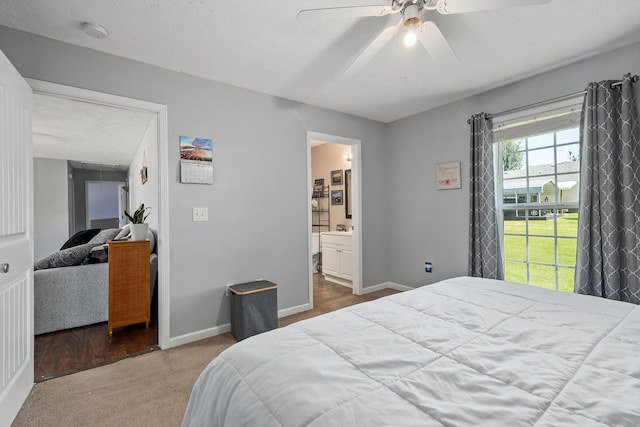 carpeted bedroom with a textured ceiling, ceiling fan, and ensuite bathroom