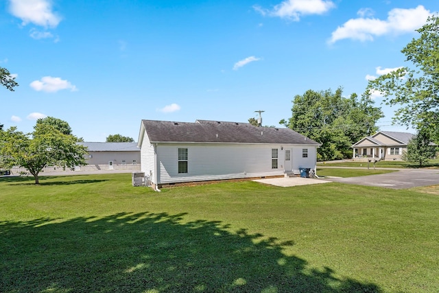 back of property featuring a yard, cooling unit, and a patio area