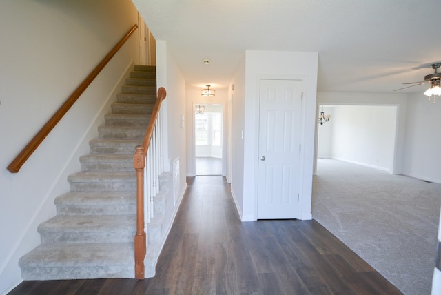 staircase featuring ceiling fan with notable chandelier and wood-type flooring