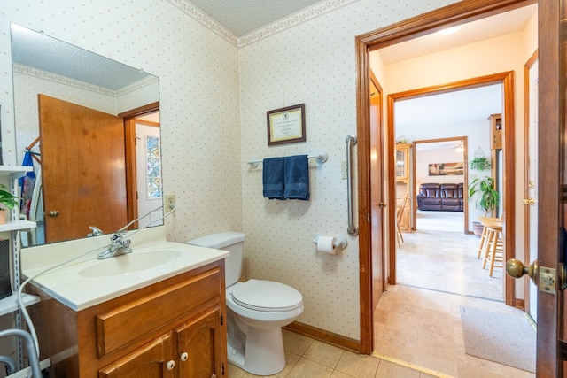 bathroom with tile patterned flooring, vanity, a textured ceiling, and toilet