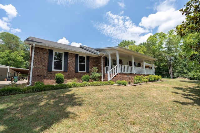 view of front of house featuring covered porch, a carport, and a front lawn