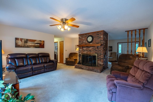 carpeted living room with ceiling fan, a textured ceiling, and a brick fireplace