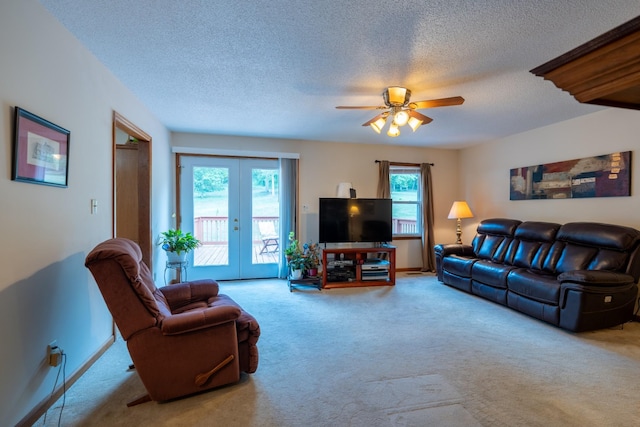 living room featuring ceiling fan, a healthy amount of sunlight, light carpet, and french doors