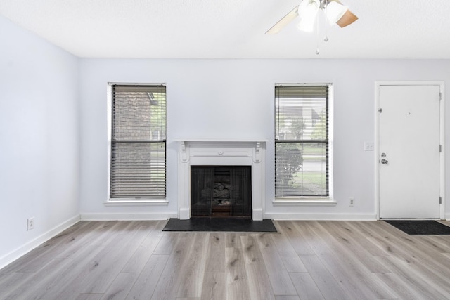 unfurnished living room with ceiling fan and light hardwood / wood-style flooring