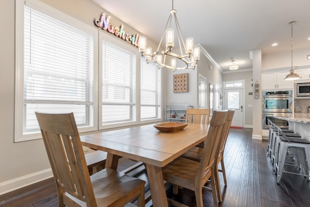 dining room with dark hardwood / wood-style floors, a healthy amount of sunlight, crown molding, and an inviting chandelier