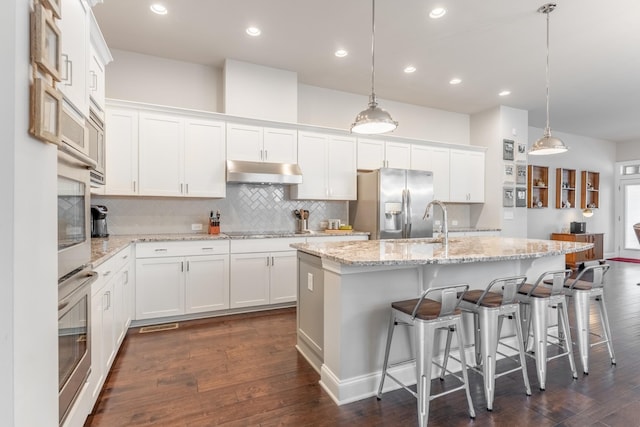 kitchen featuring white cabinetry and a center island with sink