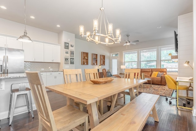 dining area with dark hardwood / wood-style flooring and ceiling fan with notable chandelier