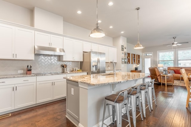 kitchen featuring white cabinets, sink, stainless steel refrigerator with ice dispenser, and hanging light fixtures