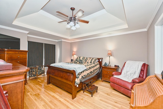 bedroom with a raised ceiling, ceiling fan, light hardwood / wood-style floors, and ornamental molding