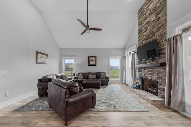 living room with high vaulted ceiling, a wealth of natural light, and light hardwood / wood-style flooring