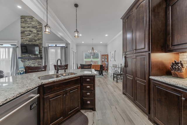 kitchen featuring dishwasher, light hardwood / wood-style floors, sink, and decorative light fixtures