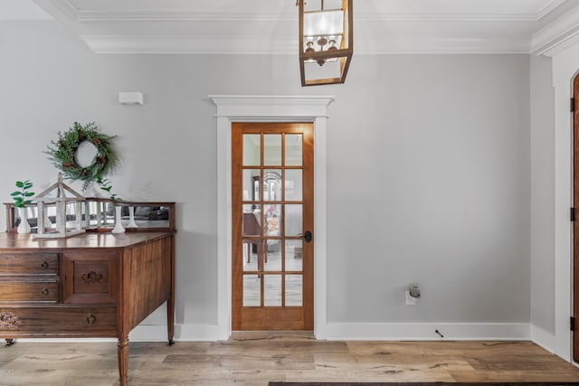 doorway to outside with crown molding, light hardwood / wood-style floors, and an inviting chandelier