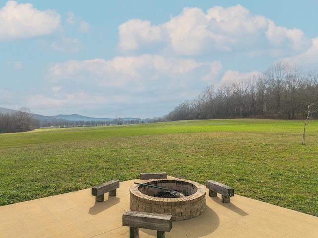 view of yard with a mountain view, a rural view, a fire pit, and a patio