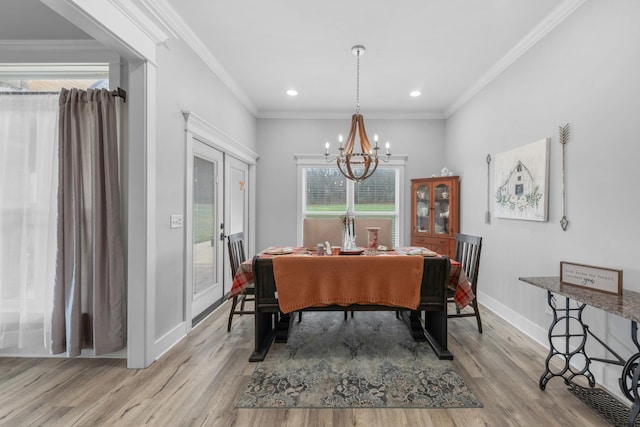 dining space featuring french doors, an inviting chandelier, ornamental molding, and light wood-type flooring