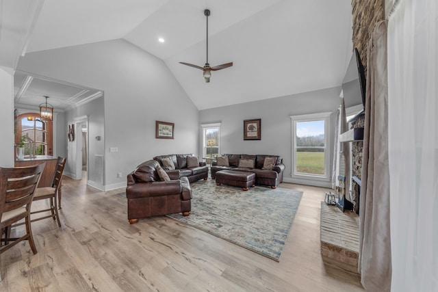 living room with ceiling fan, a fireplace, a healthy amount of sunlight, and light hardwood / wood-style floors