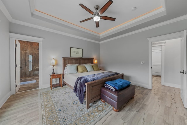 bedroom featuring ceiling fan, a raised ceiling, light hardwood / wood-style flooring, and ensuite bath