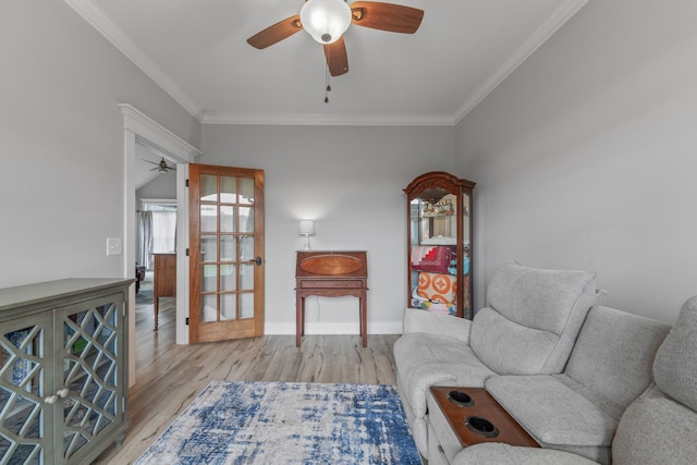 living area with light wood-type flooring, ceiling fan, and crown molding