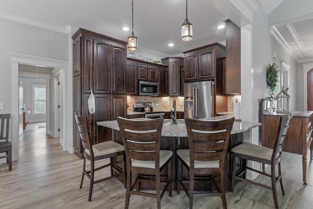 kitchen with light wood-type flooring, light stone counters, dark brown cabinets, stainless steel appliances, and crown molding