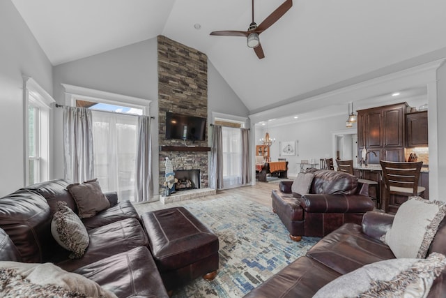 living room with ceiling fan, a fireplace, high vaulted ceiling, and wood-type flooring