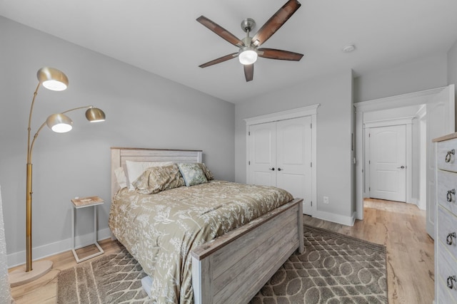 bedroom featuring ceiling fan, wood-type flooring, and a closet