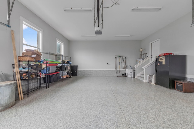 garage featuring black fridge and a garage door opener