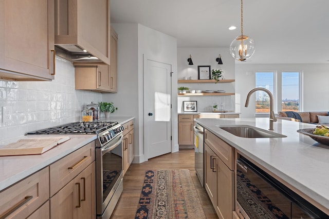 kitchen featuring appliances with stainless steel finishes, hanging light fixtures, light hardwood / wood-style floors, light brown cabinets, and sink