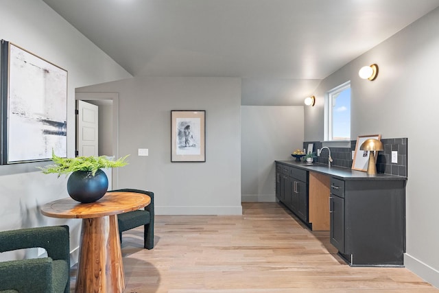 kitchen with sink, light wood-type flooring, and tasteful backsplash