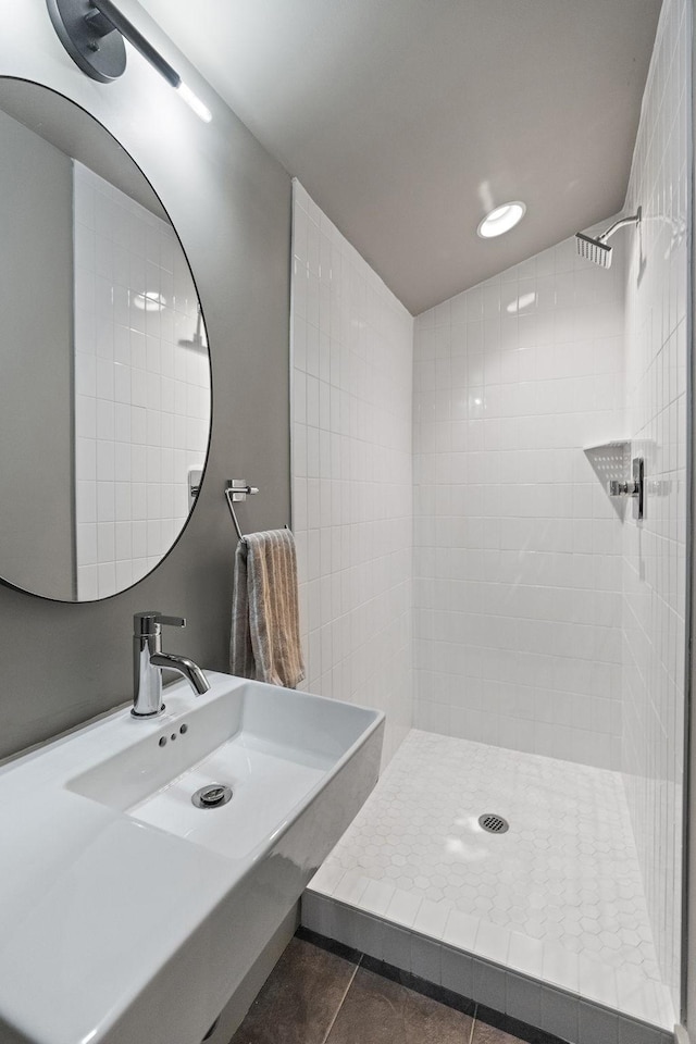 bathroom with sink, a tile shower, and tile patterned flooring