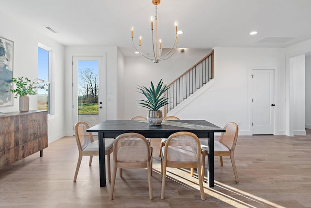 dining area with a notable chandelier and light hardwood / wood-style flooring