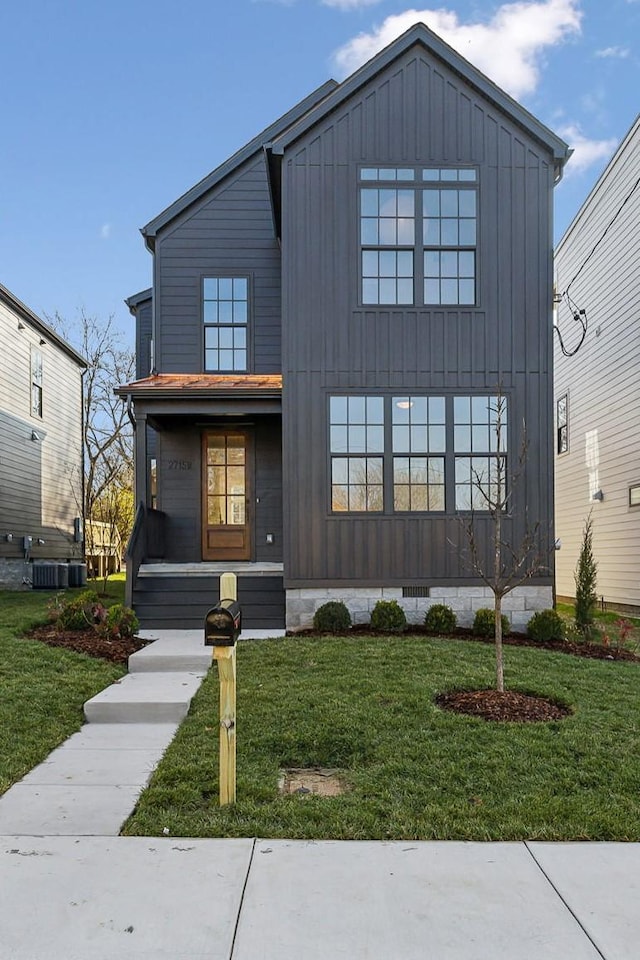 view of front of home featuring cooling unit and a front yard