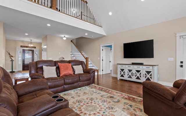 living room featuring a towering ceiling, dark hardwood / wood-style floors, and a notable chandelier