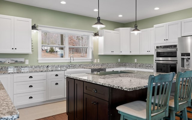 3868 Hobbstown Rd, Dunlap, TN 37327 - kitchen with stainless steel appliances, white cabinets, a breakfast bar area, a kitchen island, and light stone countertops