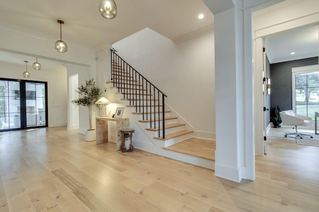 stairs featuring hardwood / wood-style floors, french doors, and crown molding