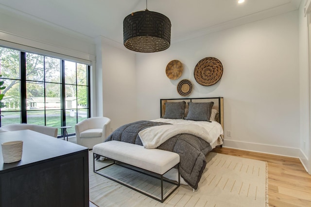 bedroom with light wood-type flooring and ornamental molding