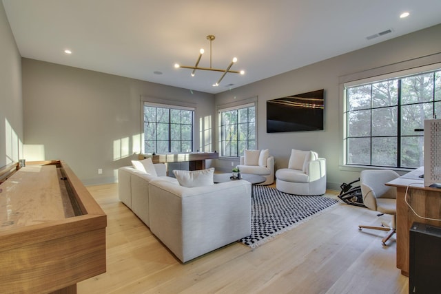 living room featuring a notable chandelier and light hardwood / wood-style flooring