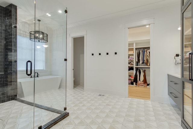 bathroom with a chandelier and shower with separate bathtub