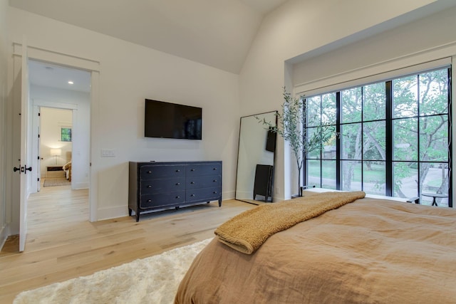 bedroom with light wood-type flooring and lofted ceiling